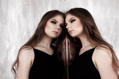 Genç kız güzel uzun saçlı ve dumanlı giyen siyah maxi bir ayna ile poz Abiye gözler. Stüdyo vurdu