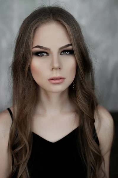 Chica joven con el pelo largo y hermoso y ojos ahumados usando maxi vestido de noche negro. Captura de estudio —  Fotos de Stock