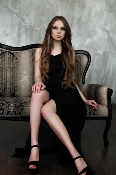 Chica joven con el pelo largo y hermoso y ojos ahumados usando maxi vestido de noche negro. Captura de estudio —  Fotos de Stock