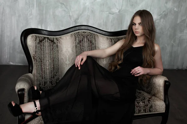 Chica joven con el pelo largo y hermoso y ojos ahumados usando maxi vestido de noche negro. Captura de estudio —  Fotos de Stock