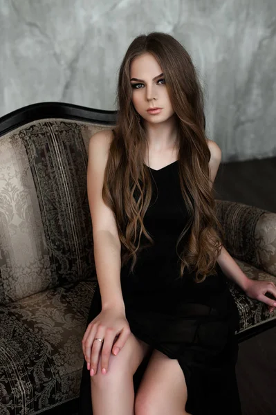 Chica joven con el pelo largo y hermoso y ojos ahumados usando maxi vestido de noche negro. Captura de estudio —  Fotos de Stock