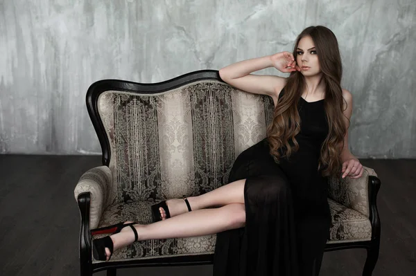 어린 소녀 긴 아름 다운 머리와 연기가 자욱한 눈 입고 블랙 맥시 이브닝 드레스. 스튜디오 촬영 — 스톡 사진