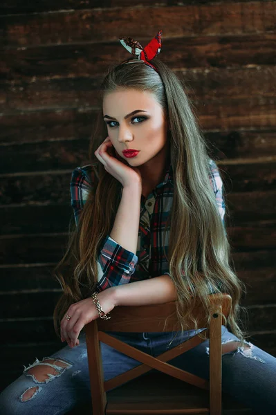 Menina jovem atraente sorrindo com aparência de país, tiro de estúdio, estilo country americano. Fundo de madeira — Fotografia de Stock