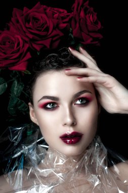 Güzellik moda Model kadın yüzü. Öğe, dikey, kırmızı gül çiçekler. Kırmızı dudaklar ve çivi. Güzel esmer kadın lüks makyaj, cilt mükemmel. Sevgililer.