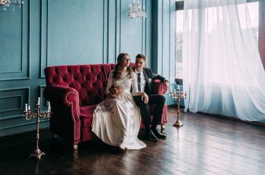 bir çift kişilik kanepe poz şirin düğün birkaç iç. Hey öp ve, birbirine bakarak elele sarılmak