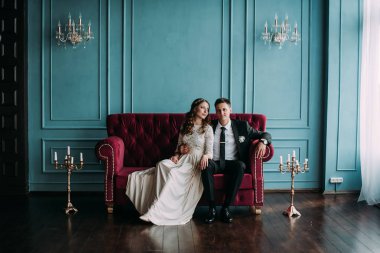 bir çift kişilik kanepe poz şirin düğün birkaç iç. Hey öp ve, birbirine bakarak elele sarılmak