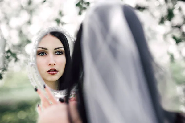 Retrato de jovem mulher de cabelos escuros no jardim florido em th — Fotografia de Stock