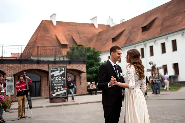 Великолепная счастливая свадебная пара гуляющая и целующаяся в старом городе Минске, Беларусь — стоковое фото