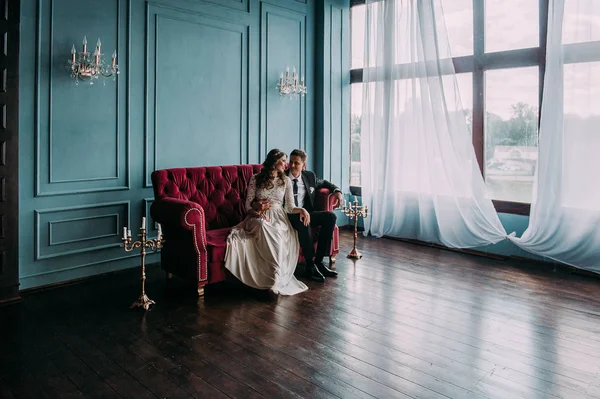 bir çift kişilik kanepe poz şirin düğün birkaç iç. Hey öp ve, birbirine bakarak elele sarılmak