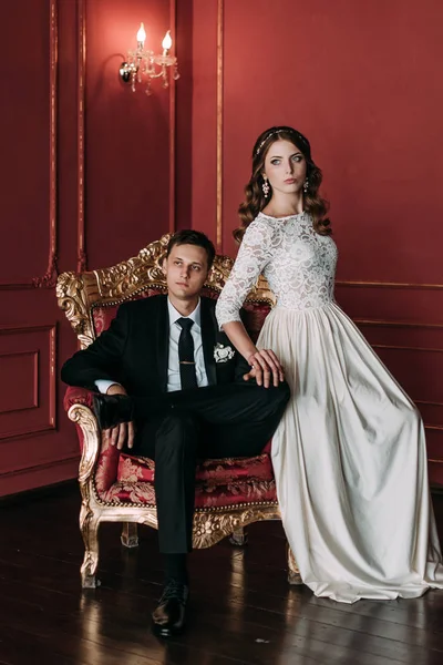 kırmızı arka plan ile klasik bir stüdyo tatlı düğün birkaç iç. Hey öp ve, birbirine bakarak elele sarılmak