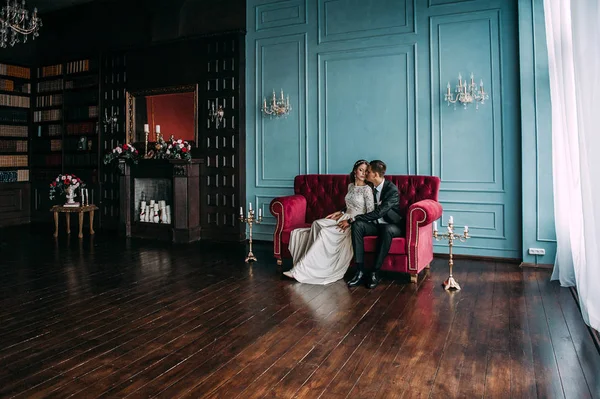 bir çift kişilik kanepe poz şirin düğün birkaç iç. Hey öp ve, birbirine bakarak elele sarılmak