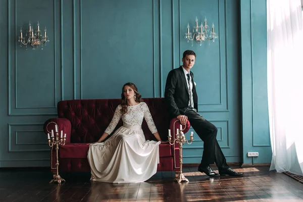 bir çift kişilik kanepe poz şirin düğün birkaç iç. Hey öp ve, birbirine bakarak elele sarılmak