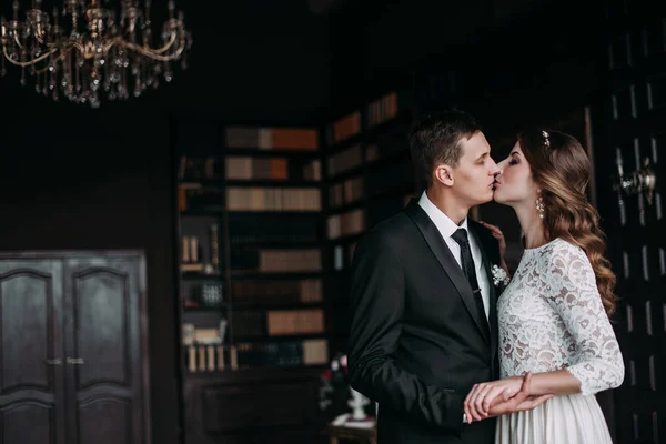 Cute wedding couple in the interior of a classic studio decorated. hey kiss and hug each other — Stock Photo, Image
