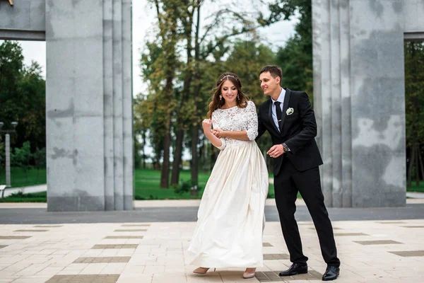 Счастливые жених и невеста в парке в день их свадьбы — стоковое фото