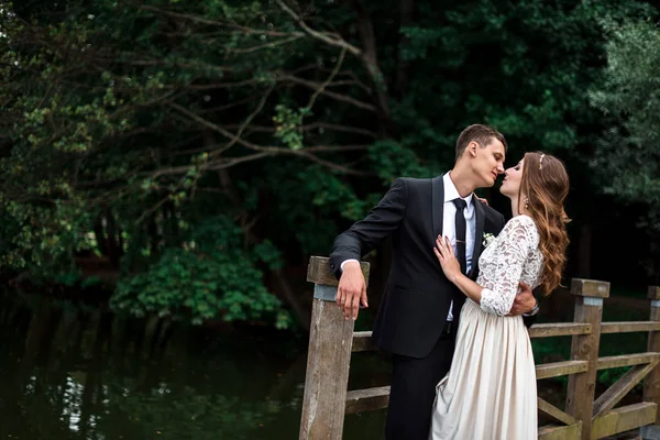 Noiva feliz e noivo em um parque em seu dia do casamento — Fotografia de Stock