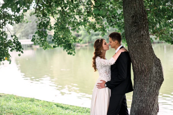 Noiva feliz e noivo em um parque em seu dia do casamento — Fotografia de Stock