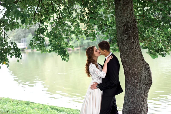 Noiva feliz e noivo em um parque em seu dia do casamento — Fotografia de Stock