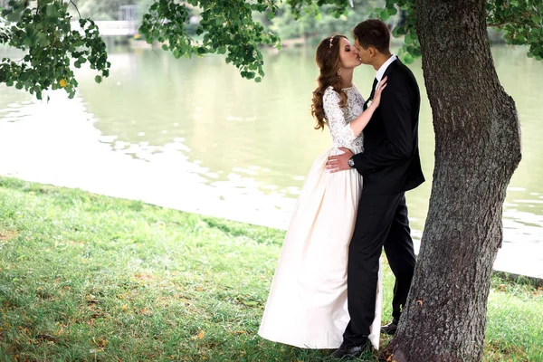 Šťastný ženich a nevěsta v parku na jejich svatební den — Stock fotografie