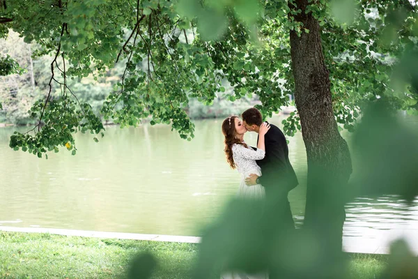 Noiva feliz e noivo em um parque em seu dia do casamento — Fotografia de Stock