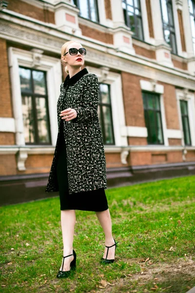 코트와 hight 발뒤꿈치와 안경 오래 된 벽돌 건물 근처 포즈를 입고 검은 곱슬 머리와 섹시 한 아름 다운 여자의 패션이을 야외 사진 — 스톡 사진