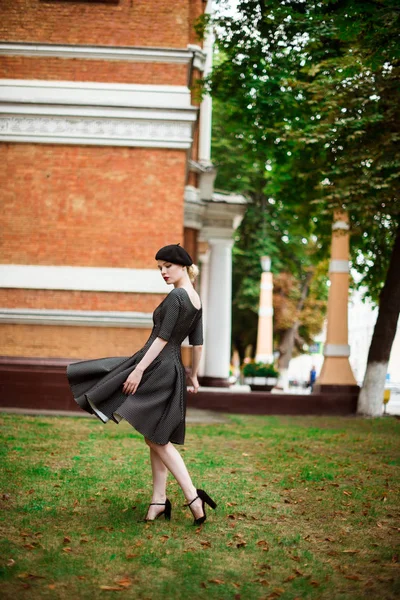 Bella ragazza bionda attraente in un vestito e berretto all'aperto — Foto Stock