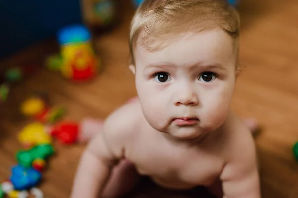 Sorrindo menino brincando com brinquedos em seu quarto — Fotografia de Stock