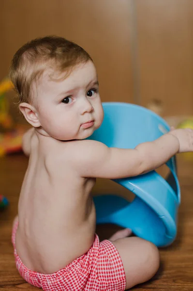 Sonriente niño jugando con un orinal en su habitación — Foto de Stock