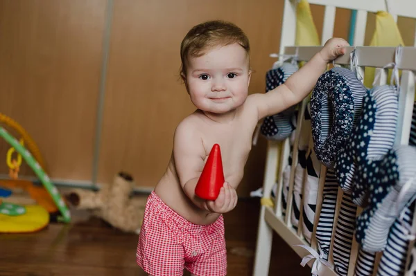 Sorrindo menino brincando com brinquedos em seu quarto — Fotografia de Stock