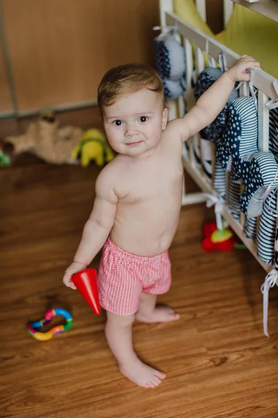 Sorrindo menino brincando com brinquedos em seu quarto — Fotografia de Stock