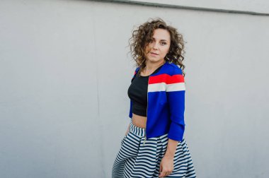 Uzun dalgalı saçlı güzel seksi genç esmer kız ince ince şekil ve oldukça uzun soyulmuş bir etek ve siyah bluz, yüksek topuklu giyiyor makyaj yüz. Rahat tarzı sokakta yürümek