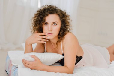 Seksi kadın güzel vücudu gösterilen sabah yatakta. Uyanmak istiyor değil. Doğal ışık yatak odasında ve yatak örtüsü ile kaplı uyandırmak.