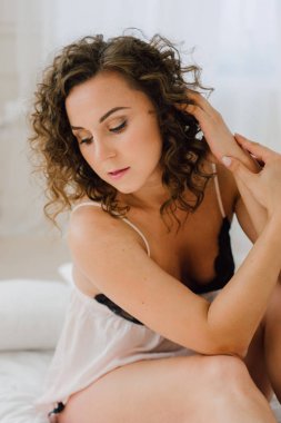 Seksi kadın güzel vücudu gösterilen sabah yatakta. Uyanmak istiyor değil. Doğal ışık yatak odasında ve yatak örtüsü ile kaplı uyandırmak.