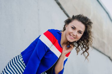 Uzun dalgalı saçlı güzel seksi genç esmer kız ince ince şekil ve oldukça uzun soyulmuş bir etek ve siyah bluz, yüksek topuklu giyiyor makyaj yüz. Rahat tarzı sokakta yürümek