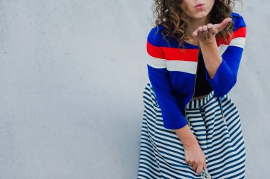 Uzun dalgalı saçlı güzel seksi genç esmer kız ince ince şekil ve oldukça uzun soyulmuş bir etek ve siyah bluz, yüksek topuklu giyiyor makyaj yüz. Rahat tarzı sokakta yürümek