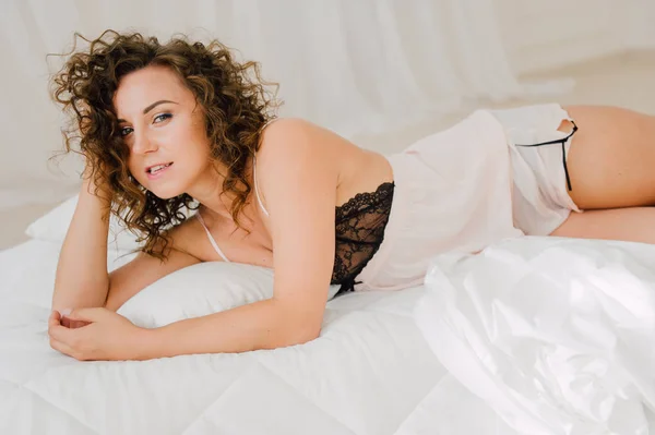 Donna sexy a letto la mattina mostrando il suo bel corpo. Lei non vuole svegliarsi. Svegliarsi con luce naturale nella sua camera da letto e coperto con le lenzuola . — Foto Stock