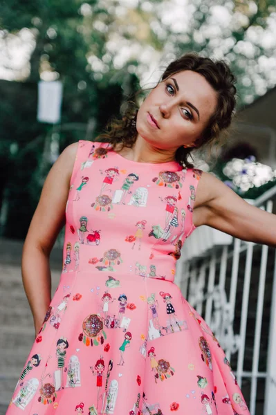 熱帯植物の近くの外のピンクのドレスでポーズ美しいブルネットの少女 — ストック写真
