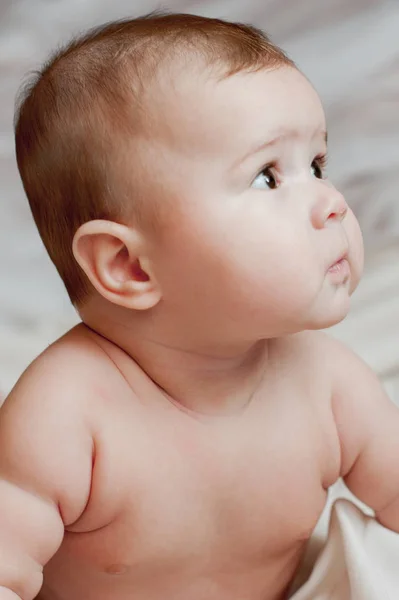 Imagen suave de un hermoso bebé acostado sobre ropa de cama blanca — Foto de Stock