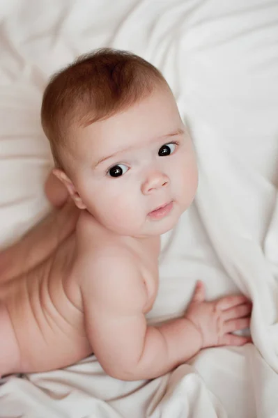 Immagine morbida di un bel bambino sdraiato su biancheria da letto bianca — Foto Stock