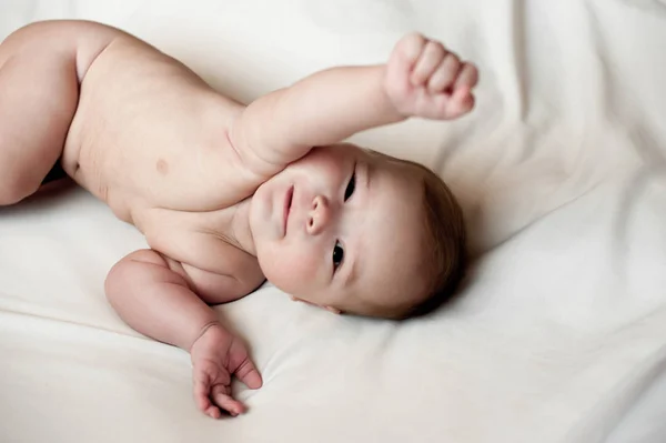Immagine morbida di un bel bambino sdraiato su biancheria da letto bianca — Foto Stock