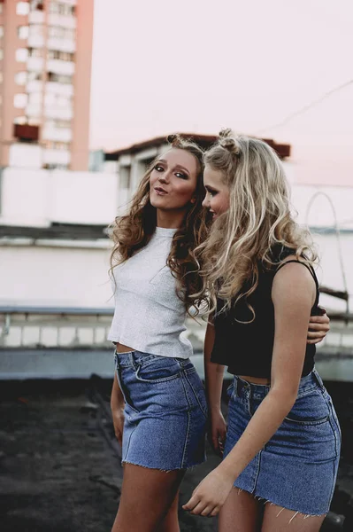 Стиль жизни и концепция людей: Модный портрет двух стильных девушек лучших друзей в джинсах юбки, на крыше. Счастливого лета для веселья. Концепция 90-х. Ретушированная фотография — стоковое фото