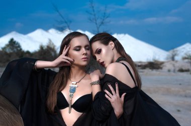 Parlak makyaj ve siyah açık havada mavi yaz göğün üzerinde poz giymiş pembe dudakları ile oldukça esmer kız. Düzeltisiz atış.