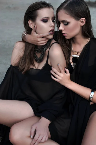 Jolies filles brunes avec un maquillage lumineux et des lèvres roses portant noir posant à l'extérieur sur le ciel bleu de l'été. Plan retravaillé . — Photo