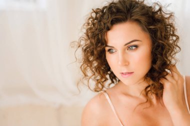 Seksi kadın güzel vücudu gösterilen sabah yatakta. Doğal ışık yatak odasında ve yatak örtüsü ile kaplı uyandırmak. Düzeltisiz fotoğraf.