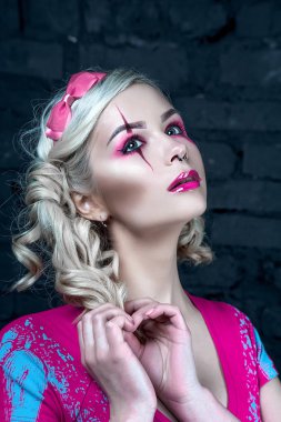 Yaratıcı bebek makyaj ile iki kuyruklu ile güzel sarışın kız: pembe Pembe iskelet elbise giyen parlak dudaklar. Cadılar Bayramı partisi için. Düzeltisiz görüntü kadar yakın.