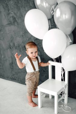 Portre sevimli küçük çocuk gülümseyen kutluyor 1 yıl kutlu olsun. Baloons ile oynarken bir yıl eski Avrupa küçük beyefendi