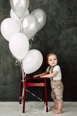 Portre sevimli küçük çocuk gülümseyen kutluyor 1 yıl kutlu olsun. Baloons ile oynarken bir yıl eski Avrupa küçük beyefendi