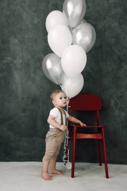 Portre sevimli küçük çocuk gülümseyen kutluyor 1 yıl kutlu olsun. Baloons ile oynarken bir yıl eski Avrupa küçük beyefendi