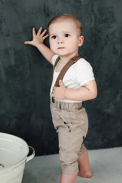 Retrato del adorable niño feliz sonriendo celebrando 1 año de cumpleaños. Niño europeo de un año sentado en el suelo en el estudio — Foto de Stock