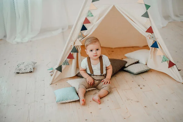 Portre sevimli küçük çocuk gülümseyen kutluyor 1 yıl kutlu olsun. Bir bebek çadır Kızılderili çadırı içinde oturan bir yıl eski Avrupa küçük bey — Stok fotoğraf