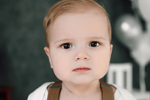 Retrato del adorable niño feliz sonriendo celebrando 1 año de cumpleaños. Niño europeo de un año sentado en el suelo en el estudio — Foto de Stock